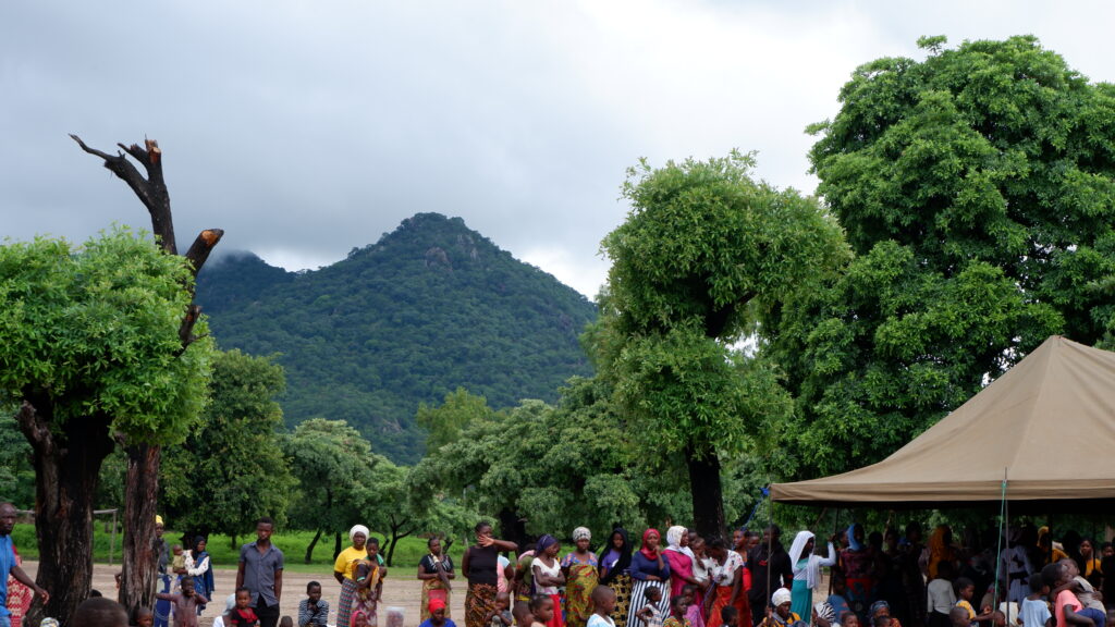 Malawi Trialogue women participants sitting outdoors, with nature on the background